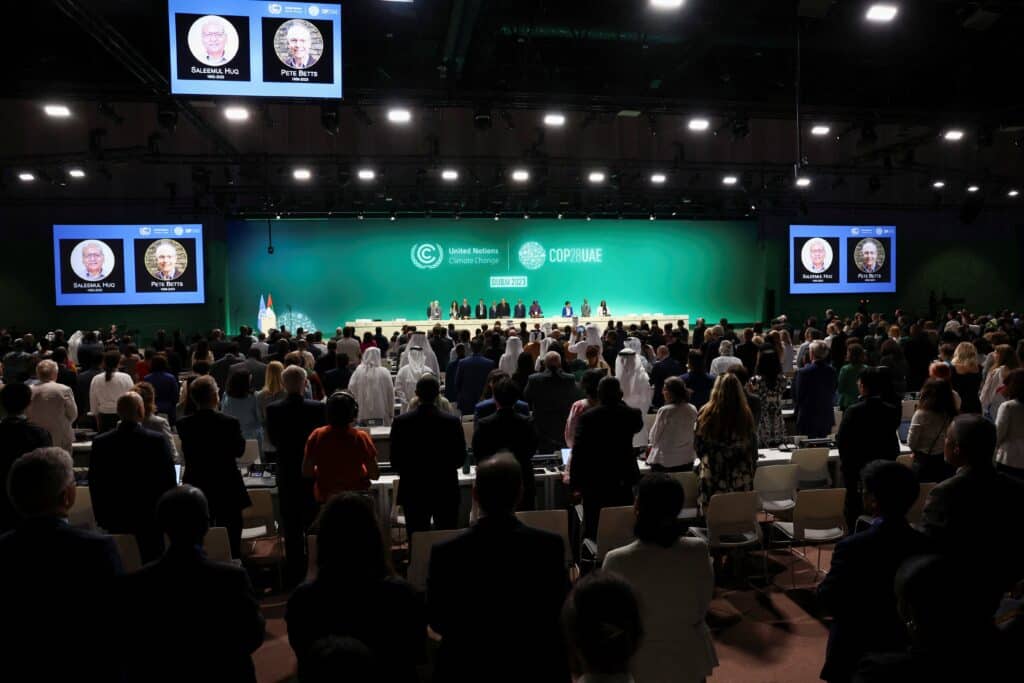 People stand for a moment of silence for victims in Gaza Nov. 30, 2023, during the opening day of the United Nations Climate Change Conference, known as COP28, in Dubai, United Arab Emirates. Efforts to meet climate goals must heed both the "cry of the earth" and the "cry of the poor," the chairmen of two U.S. Conference of Catholic Bishops' committees said in a joint statement Nov. 29. (OSV News photo/Amr Alfiky, Reuters)